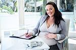 Pregnant businesswoman working at her desk