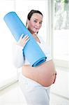 Pregnant woman holding her exercise mat