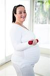 Pregnant smiling woman lifting dumbbell