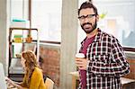 Portrait of young man holding coffee cup