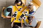 Students using smartphones and tablets in the cafe