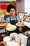 Pretty waitress serving lunch to camera