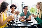 Happy students having coffee together