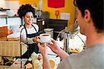 Waitress serving cappuccino to customer