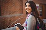 Portrait of pretty student holding tablet