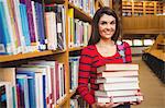 Portrait of happy student holding stack of books