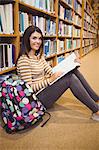 Portrait of happy female student learning in library