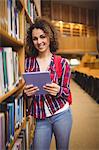 Pretty student in the library using tablet