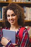 Pretty student in the library with tablet