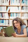 Pretty student in library reading book