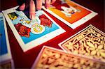 High angle view of fortune teller pointing at tarot cards