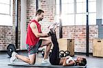 Muscular couple doing a leg stretching