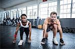 Muscular couple doing body stretching