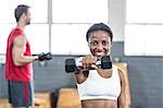 Portrait of smiling woman lifting weight