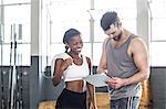 Woman discussing her performance on clipboard with a trainer