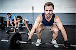 Three muscular athletes liftings barbells