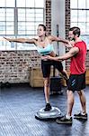 Trainer assisting woman with stretching exercises