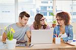 Businesspeople discussing over laptop in meeting