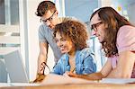 Business people smiling while looking in laptop