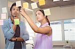 Businesswoman pointing at sticky notes