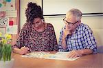 Business people discussing over documents in office