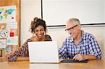 Business people discussing over laptop in office