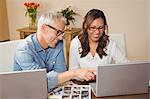 Happy business people discussing over laptop in office