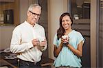 Portrait of business people holding coffee cup in office