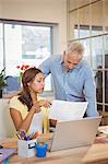 Creative businesswoman showing document to colleague