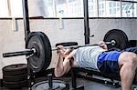 Fit man lifting heavy barbell weight