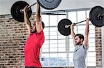 Fit people lifting barbell weight