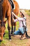 Young woman walking with her horse