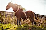 Young happy woman riding her horse