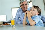 Grandfather and grandson having breakfast