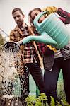 Couple watering plants together