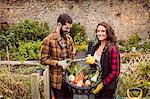 Smiling couple holding basket of vegetable