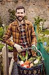 Smiling man holding basket of vegetables