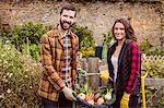 Proud couple showing basket of vegetable