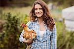 Smiling woman holding chicken