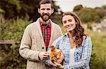 Portrait of couple holding chicken