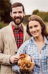 Portrait of couple holding chicken