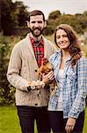 Couple holding chicken and egg