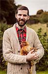 Smiling man holding chicken