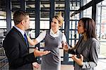 Business people arguing together while businesswoman putting hands up