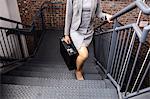 Businesswoman climbing stairs with briefcase