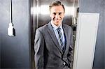 Smiling businessman standing front of elevator