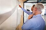 Businessman showing something on board to colleague