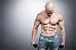 Composite image of muscular man holding dumbbells