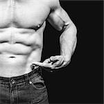Composite image of midsection of shirtless man pointing at abs