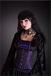 Attractive gothic girl in Victorian style clothes, studio shot on black background